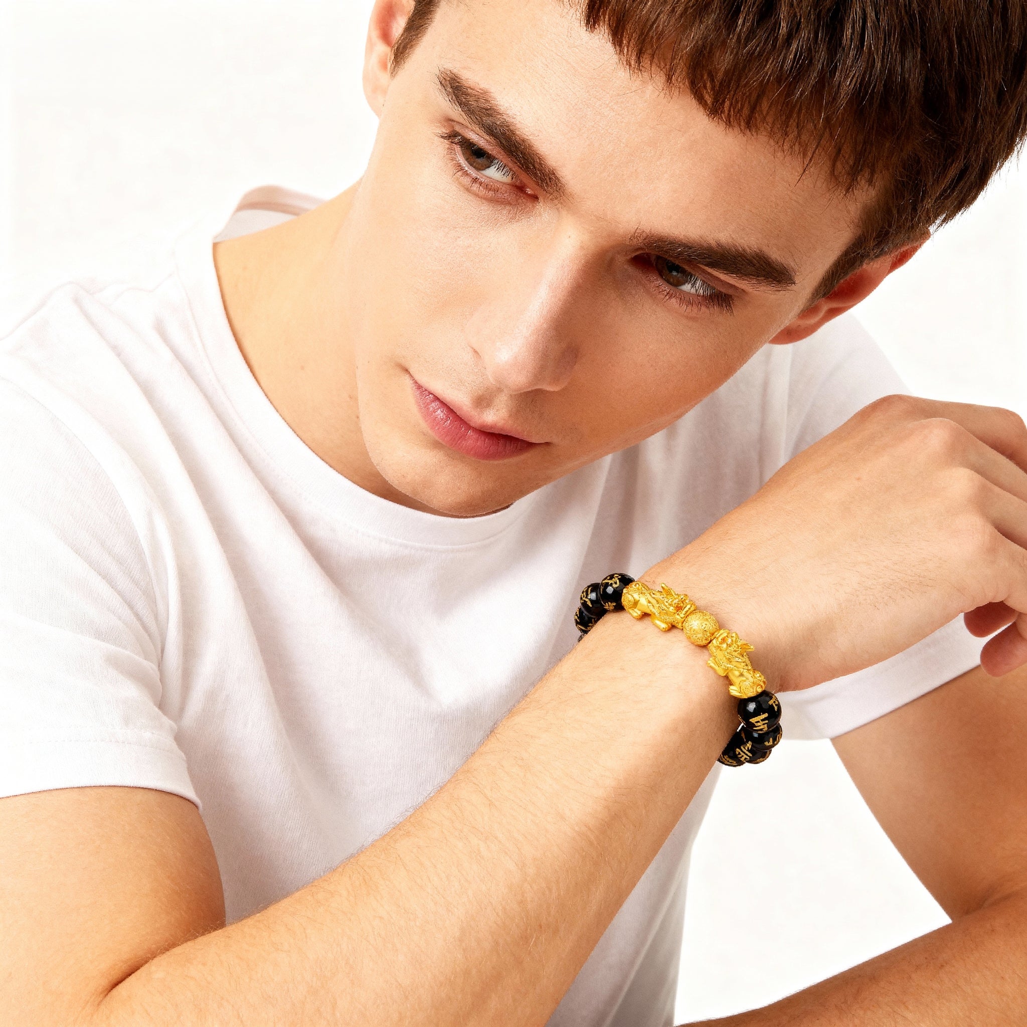 Man wearing a yellow and black beaded bracelet on a white background