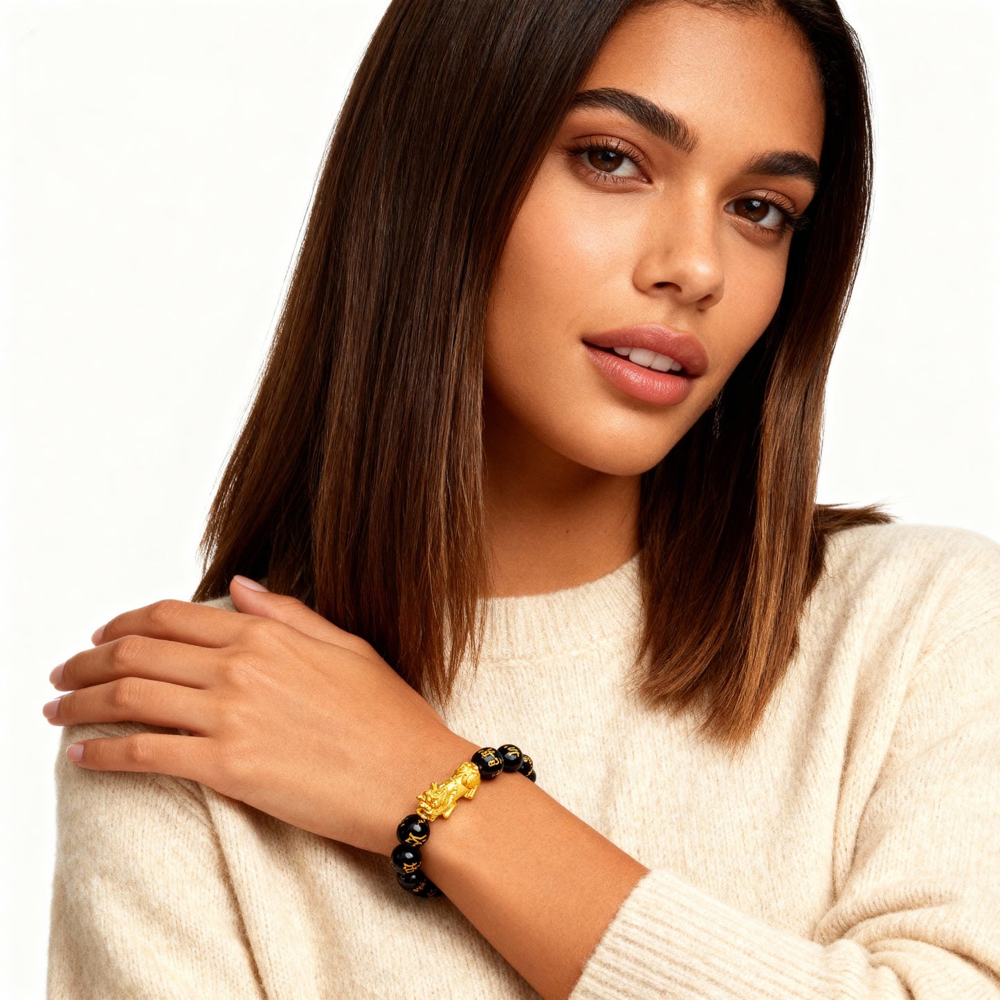 Woman wearing a beige sweater and a bracelet with a neutral background